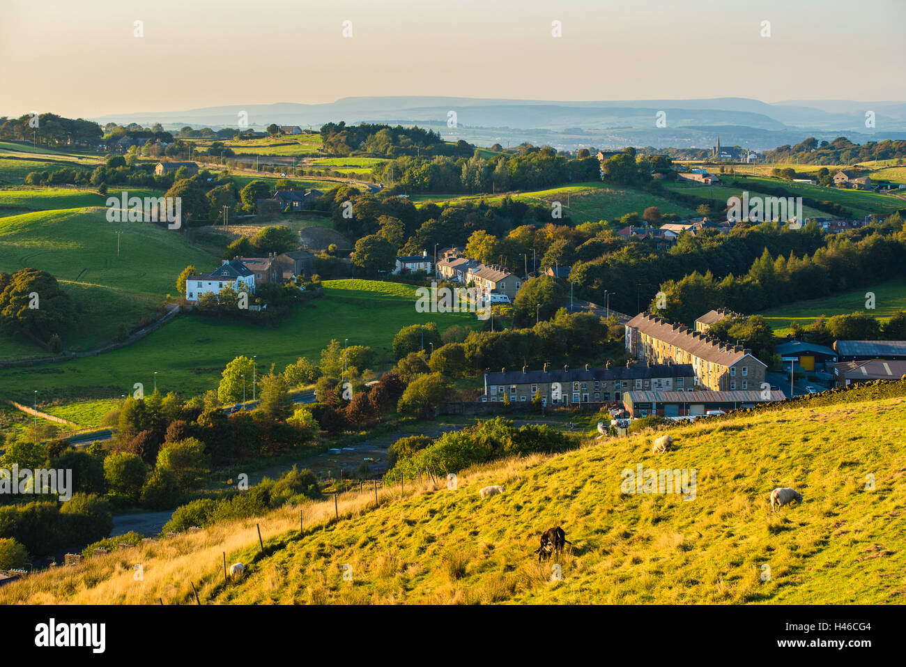 Vista distante Bowland Fells su case a schiera a Hud Hey dalle piste al di sotto della sommità di ardesia in Lancashire Pennines Foto Stock