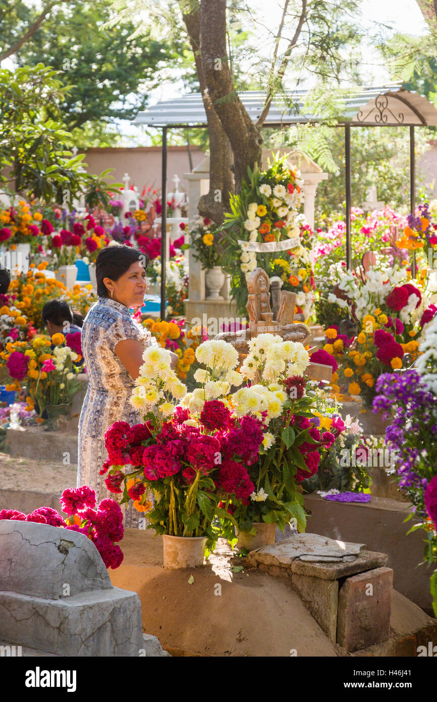 Una donna opinioni recinto decorato con elaborati floreali arazzi del pedale in onore del defunto al San Antonino Castillo cimitero durante il Giorno dei Morti Festival noto come D'un de Muertos il 3 novembre 2013 a San Antonino Castillo Velasco, Oaxaca, Messico. Foto Stock