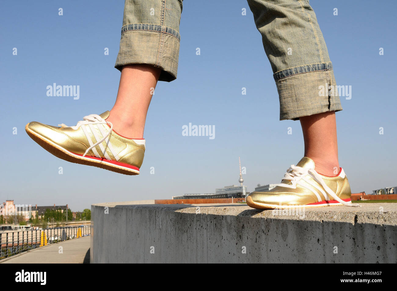 Donna, dettaglio, piedi, sneakers, crack, ossa, sport scarpe, scarpe,  Golden, stringa, apertamente, jeans, mura difensive, equilibrio, salto,  abisso, estate, viaggio, pericolo, il malleolo, hochgekrämpelt, decadono,  cielo blu, torre della radio ...