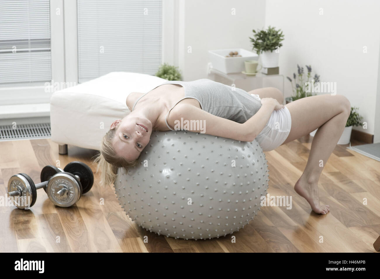 Giovane donna su una sfera di ginnastica, Foto Stock