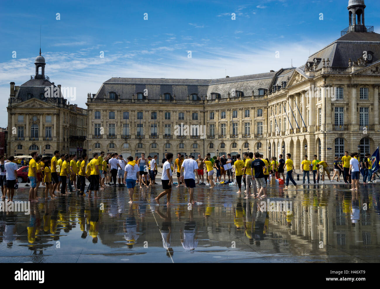 I festaioli godere di giochi su Miroir d'Eau (un grande stagno riflettente) di fronte alla Place de la Bourse di Bordeaux, Francia Foto Stock
