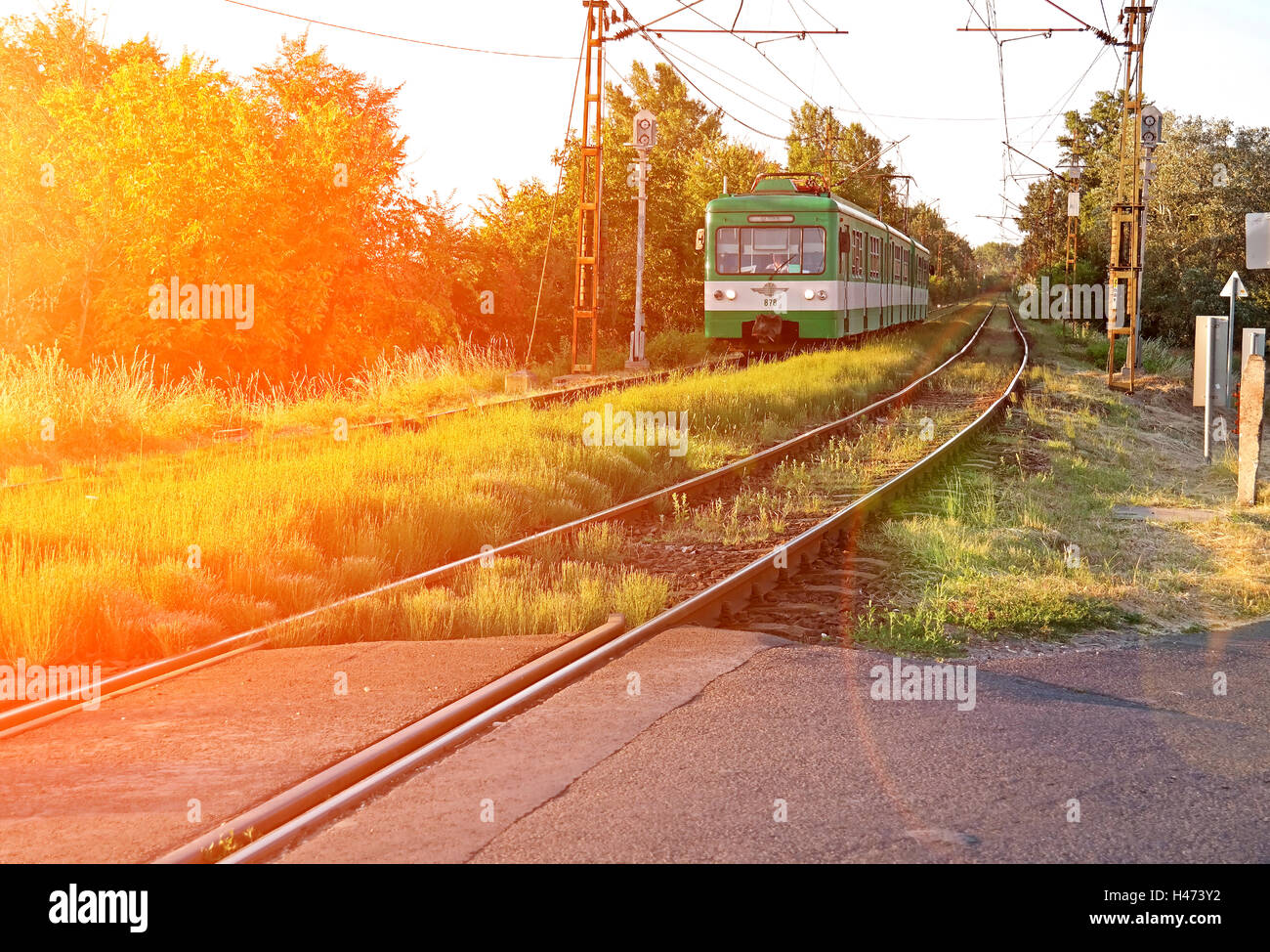 Un verde ferrovia suburbana corre in città Foto Stock