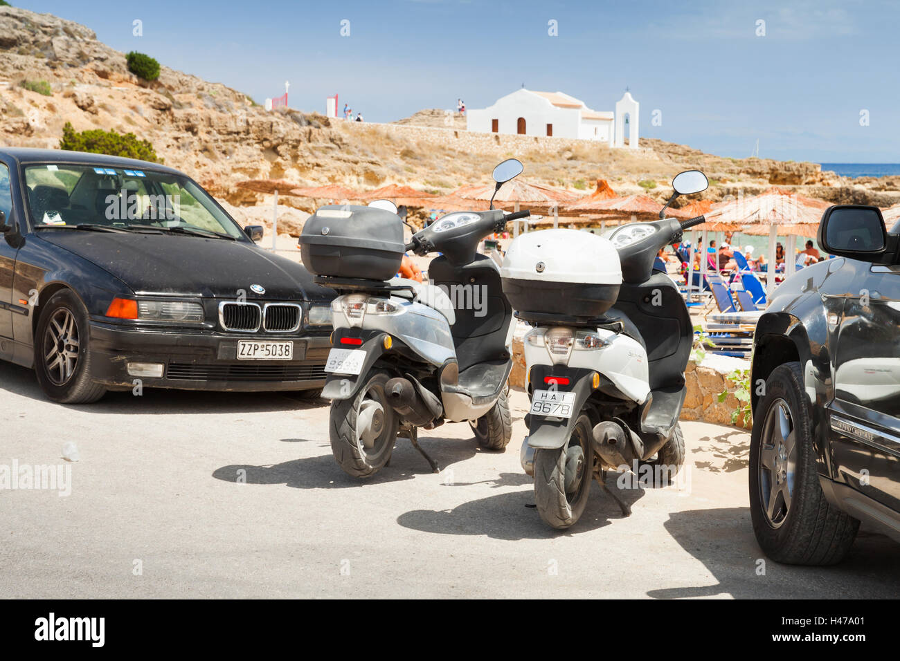 Zakynthos Greece - Agosto 18, 2016: scooter stand parcheggiata tra vetture nei pressi di Agios Nikolaos spiaggia Foto Stock