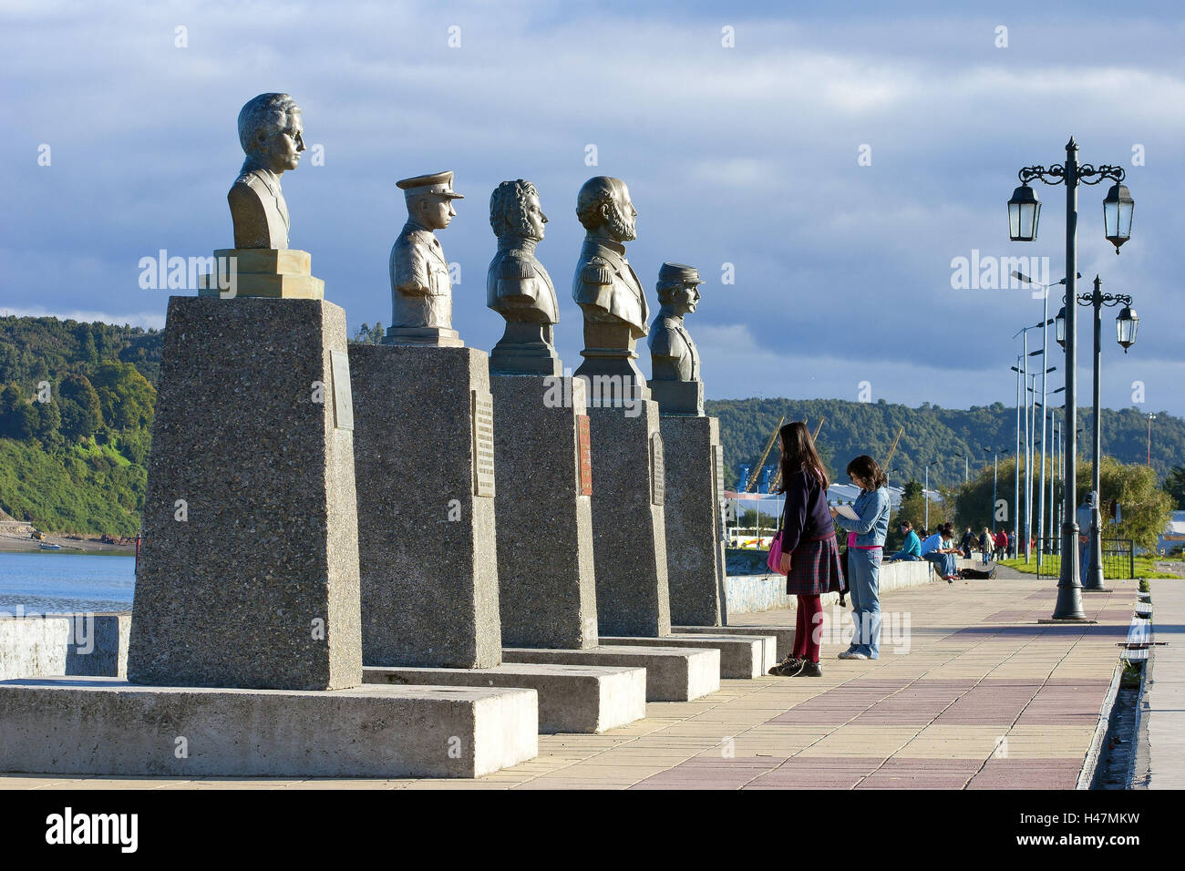 Sud America, Cile, Patagonia, Puerto Montt, porto, banca promenade, scuola ragazza guarda busti in bronzo, Foto Stock
