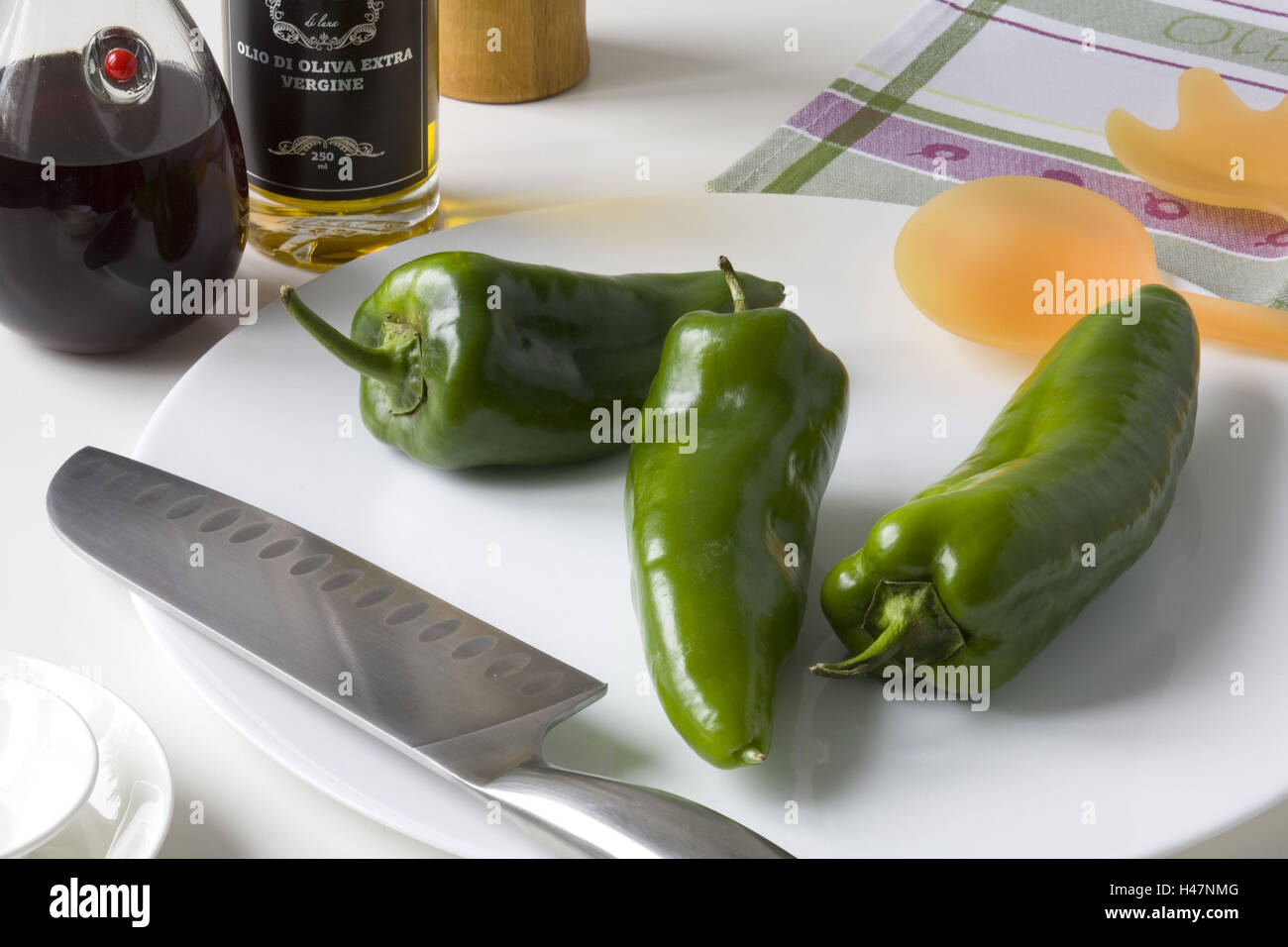 Piastra con tre green chilis e coltello, Foto Stock