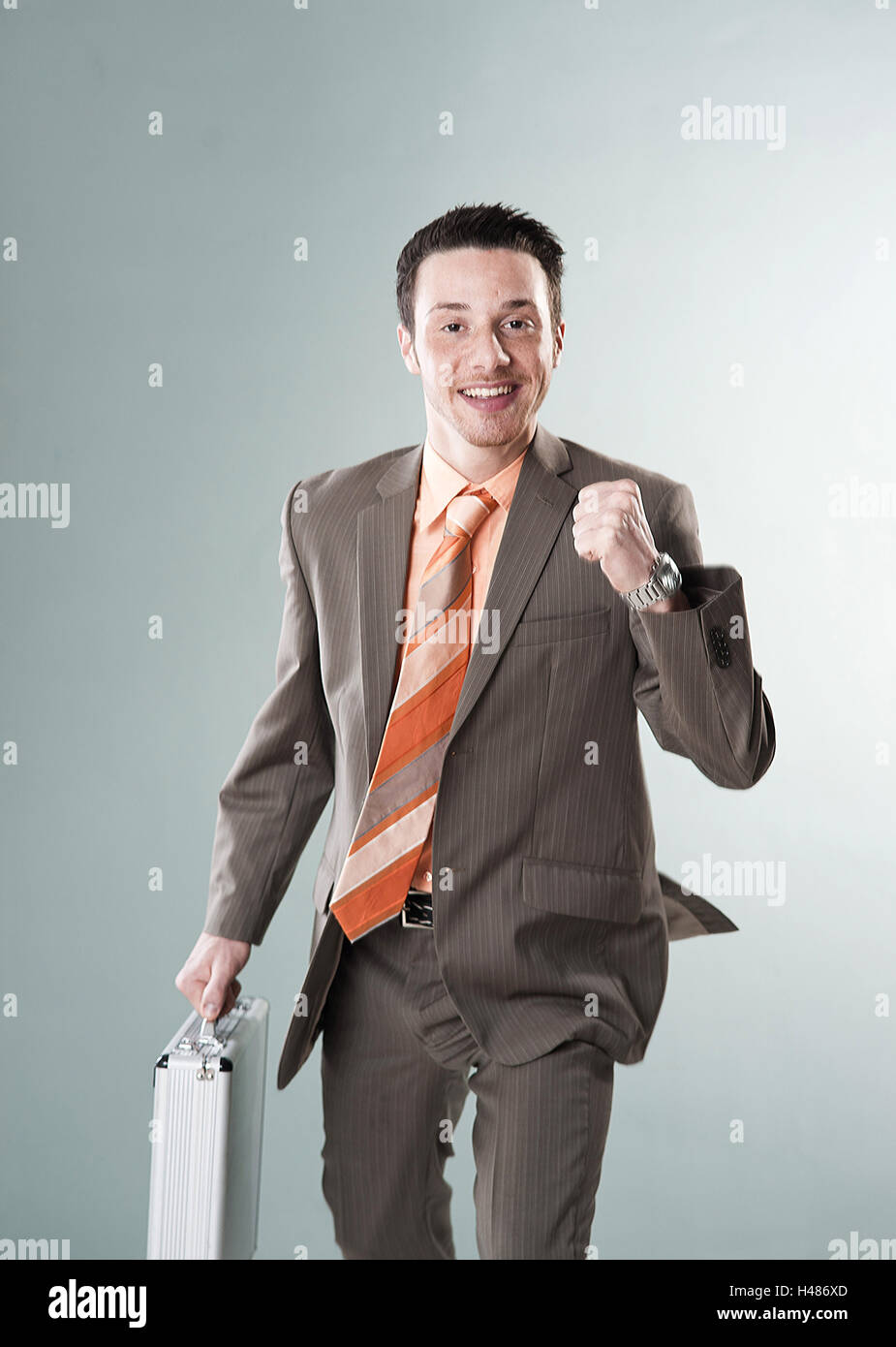 Il giovane imprenditore corre con valigetta e concentrato pugno, Foto Stock