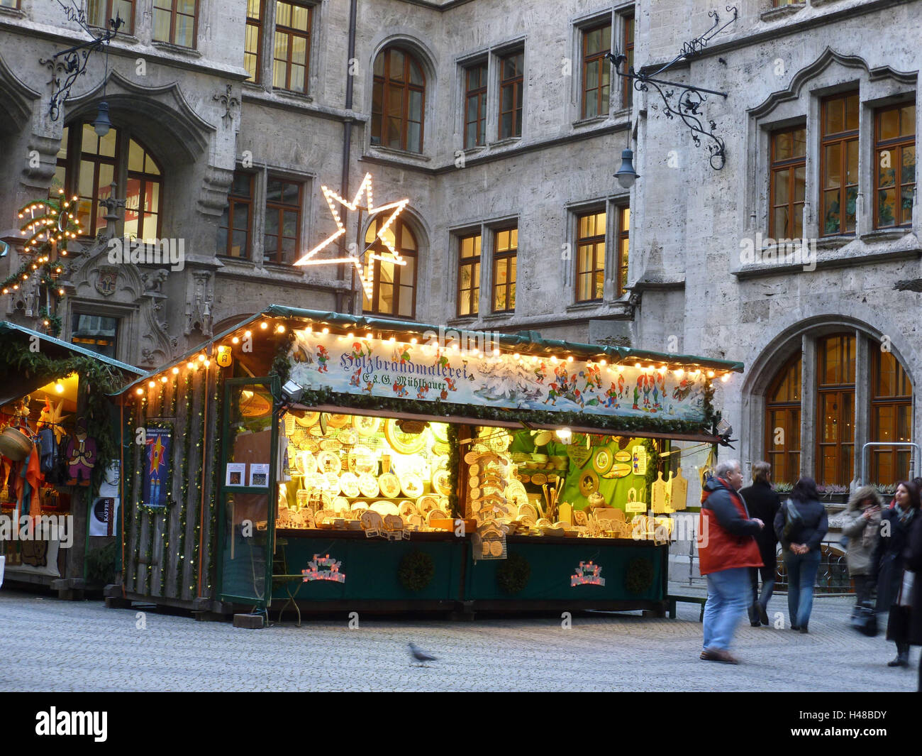 In Germania, in Baviera, Monaco di Baviera, Centro citta', la nuova city hall, city hall corte, Fiera di Natale, fuoco di legno dipinto, visitatore, crepuscolo, Foto Stock