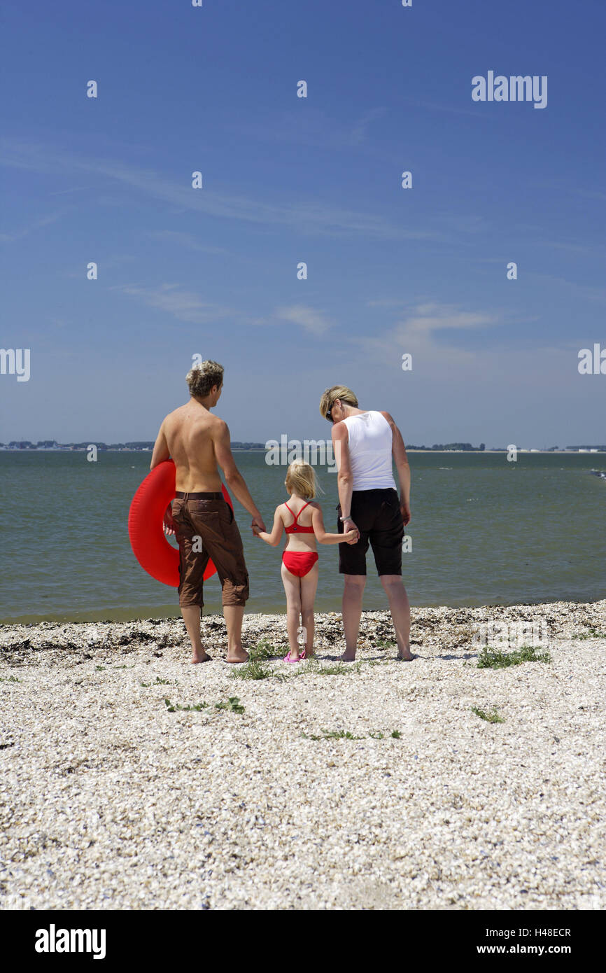 Germania, Butjadingen, il Mare del Nord, genitori, filiale, spiaggia, stand, portare con sé la vista posteriore, modello rilasciato, Germania settentrionale, persona, famiglia, bambino, ragazza, nuoto pneumatico, nuoto help, vista mare, godono, insieme, coesione, amore, vacanze, ferie, vacanze estive, vita familiare, Foto Stock