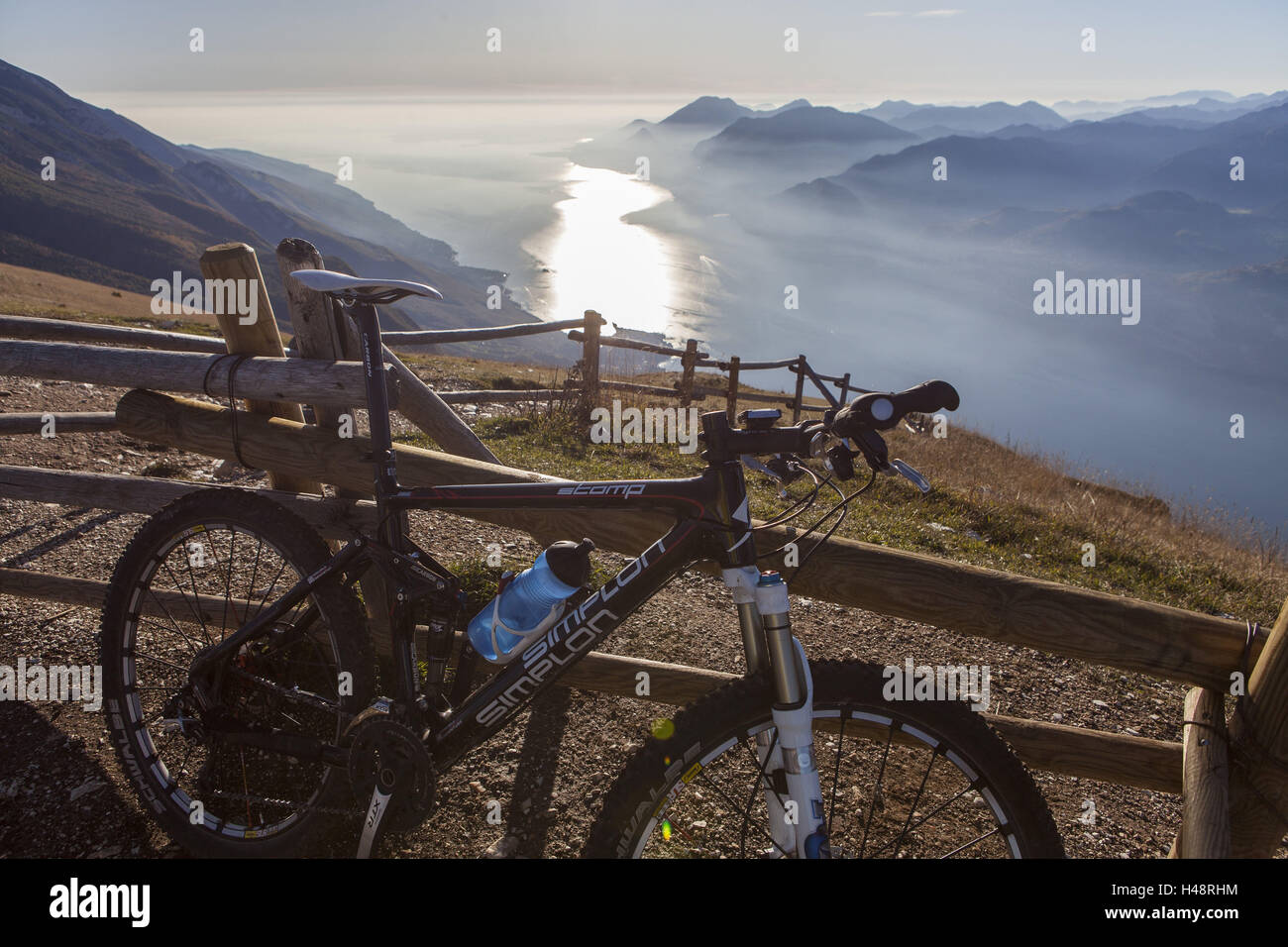 Mountain bike appoggiata contro la recinzione di legno, vista dal Monte Baldo sul Lago di Garda , Foto Stock