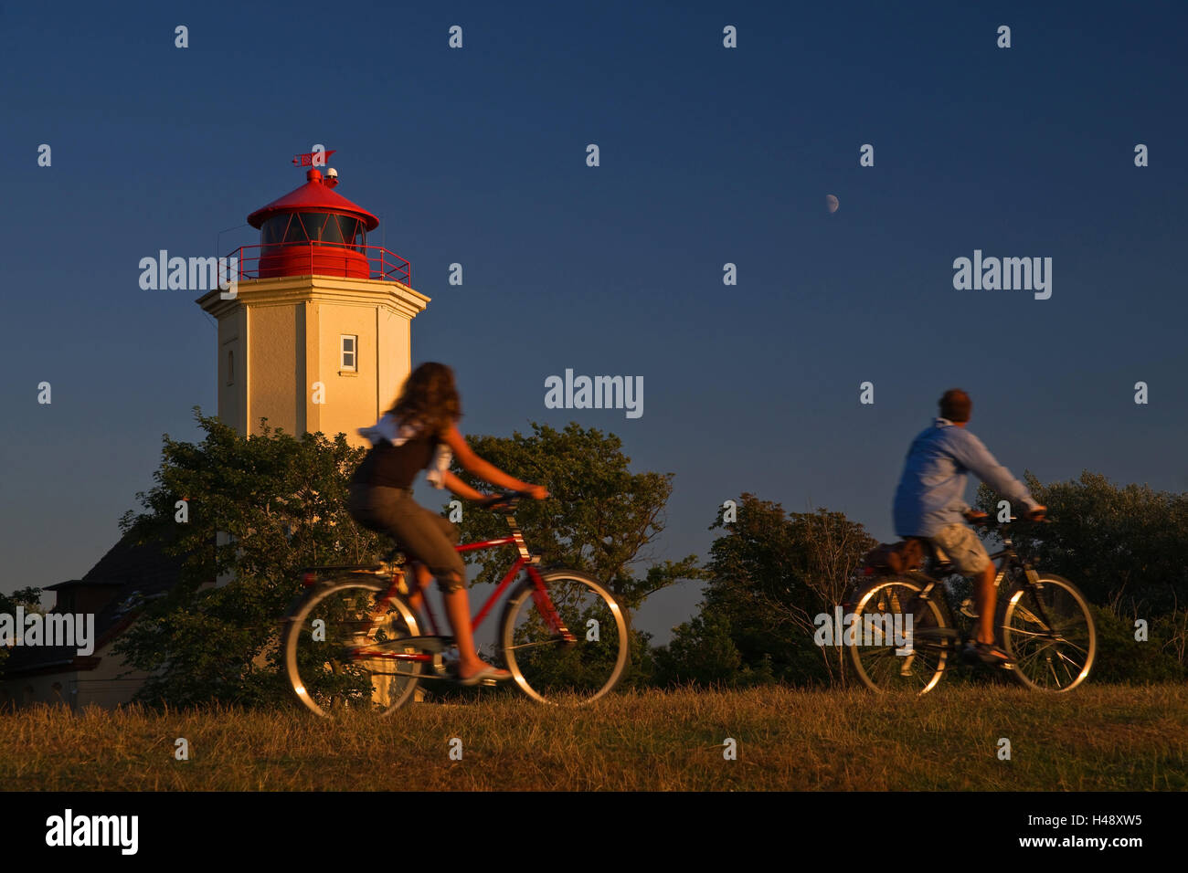 Germania, Schleswig-Holstein, Westermarkelsdorf, faro, ciclisti, Mar Baltico, estate, turisti, persone, due tour in bicicletta e a cavallo, la luce della sera, luna, vacanza, navigazione, orientamento, spedizione Foto Stock