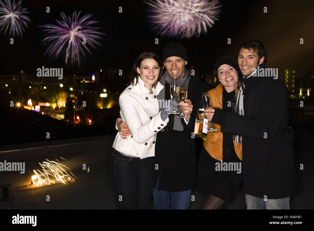 La Vigilia di Capodanno, fuochi d'artificio, giovane, chinking occhiali, allegramente, champagne, foto di gruppo, Foto Stock