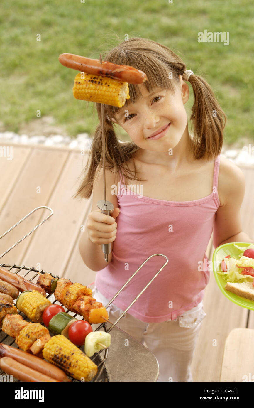 Bambino, ragazza, giardino, barbecue, grill spiedino, azienda, sorridente, ritratto, Foto Stock