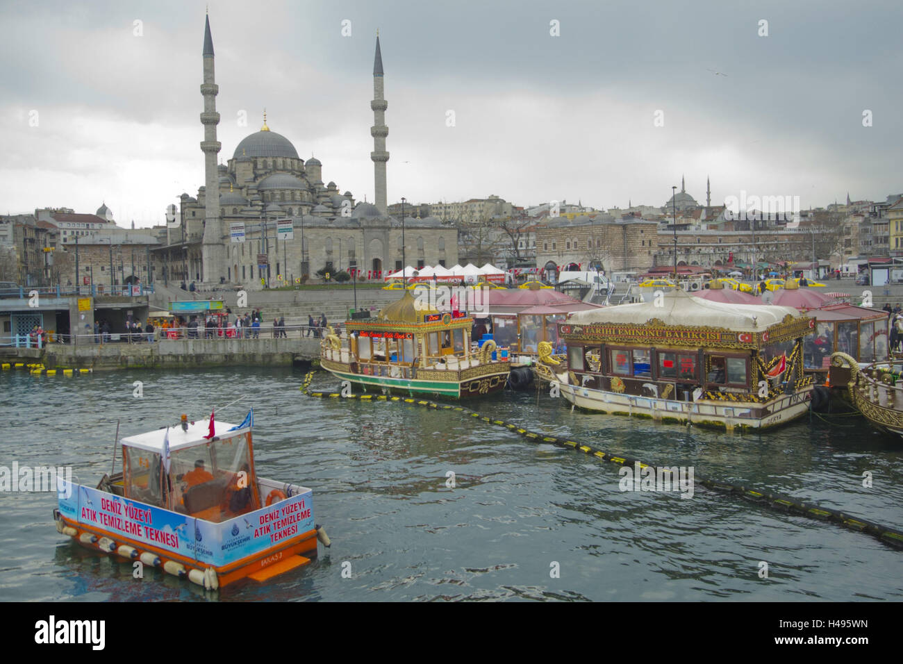 Turchia, Istanbul, Eminönü, spazio in Galatabrücke con il famoso Balik Ekmek, sullo sfondo la Yeni moschea valida o nuova moschea, nel primo piano di un tritarifiuti boot, Foto Stock