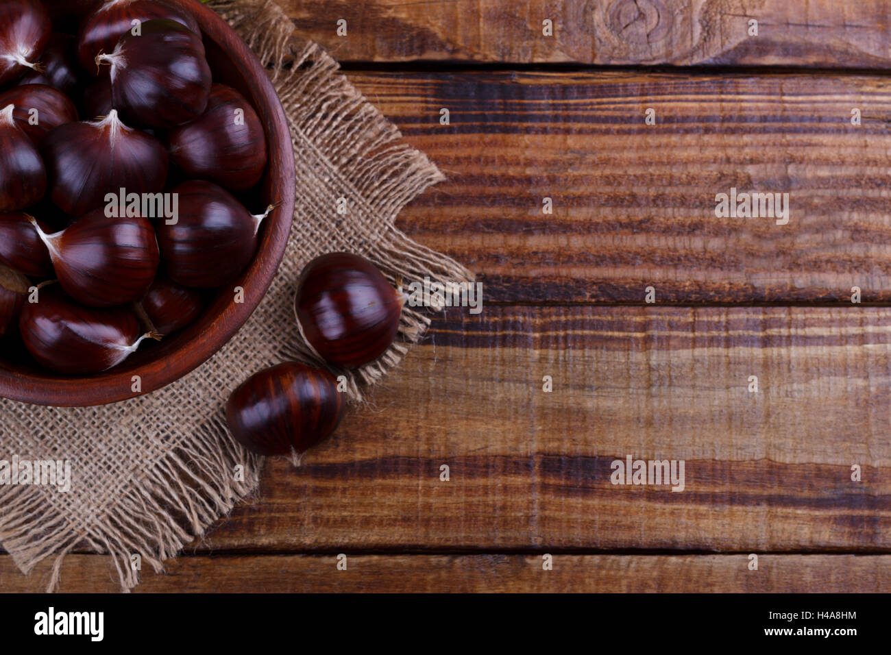 Le castagne fresche nella ciotola di legno rustico sfondo.spazio copia Foto Stock