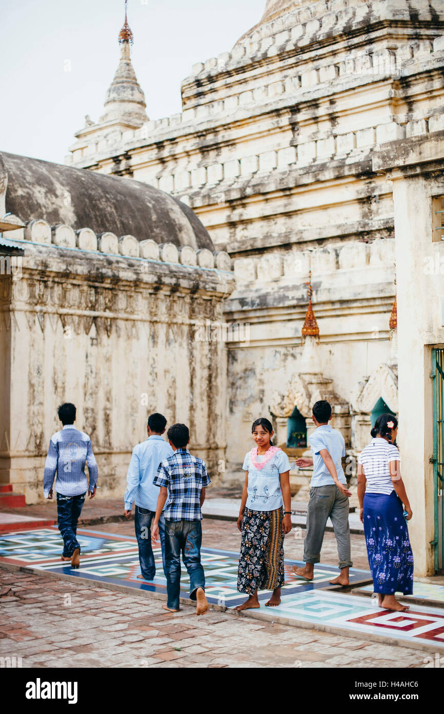 Donna locale in un gruppo di uomo visitando un tempio di Bagan, Myanmar Foto Stock