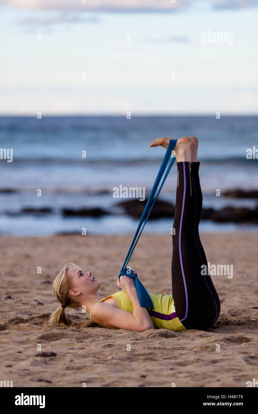 Giovane donna fare yoga e Pilates sulla spiaggia - esercizio Foto Stock