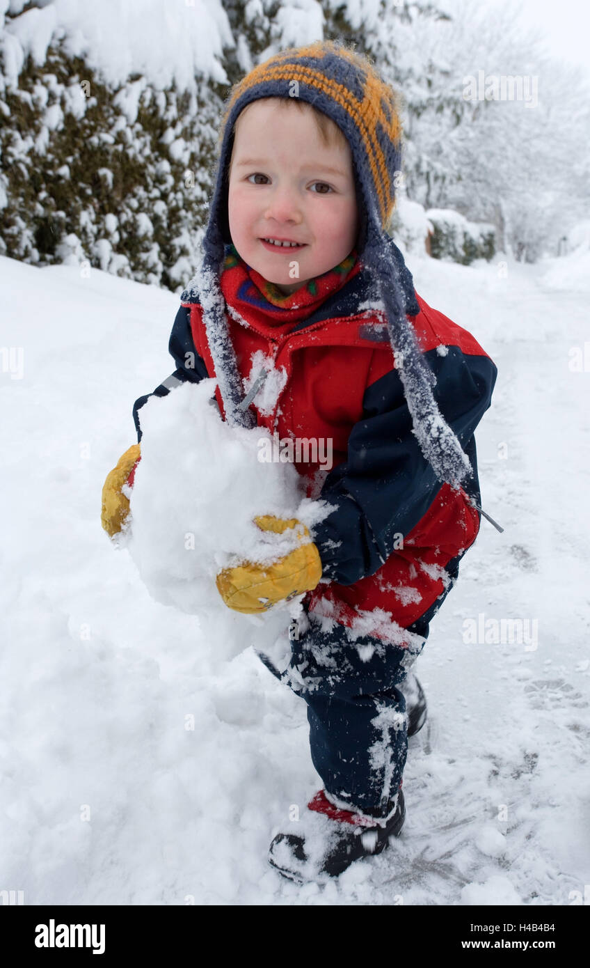 Ragazzo felice abbigliamento invernale neve giocare persone bambino stagione inverno la neve suit cappello guanti grumi grumi di neve tempo libero infanzia fuori infantile Foto stock Alamy
