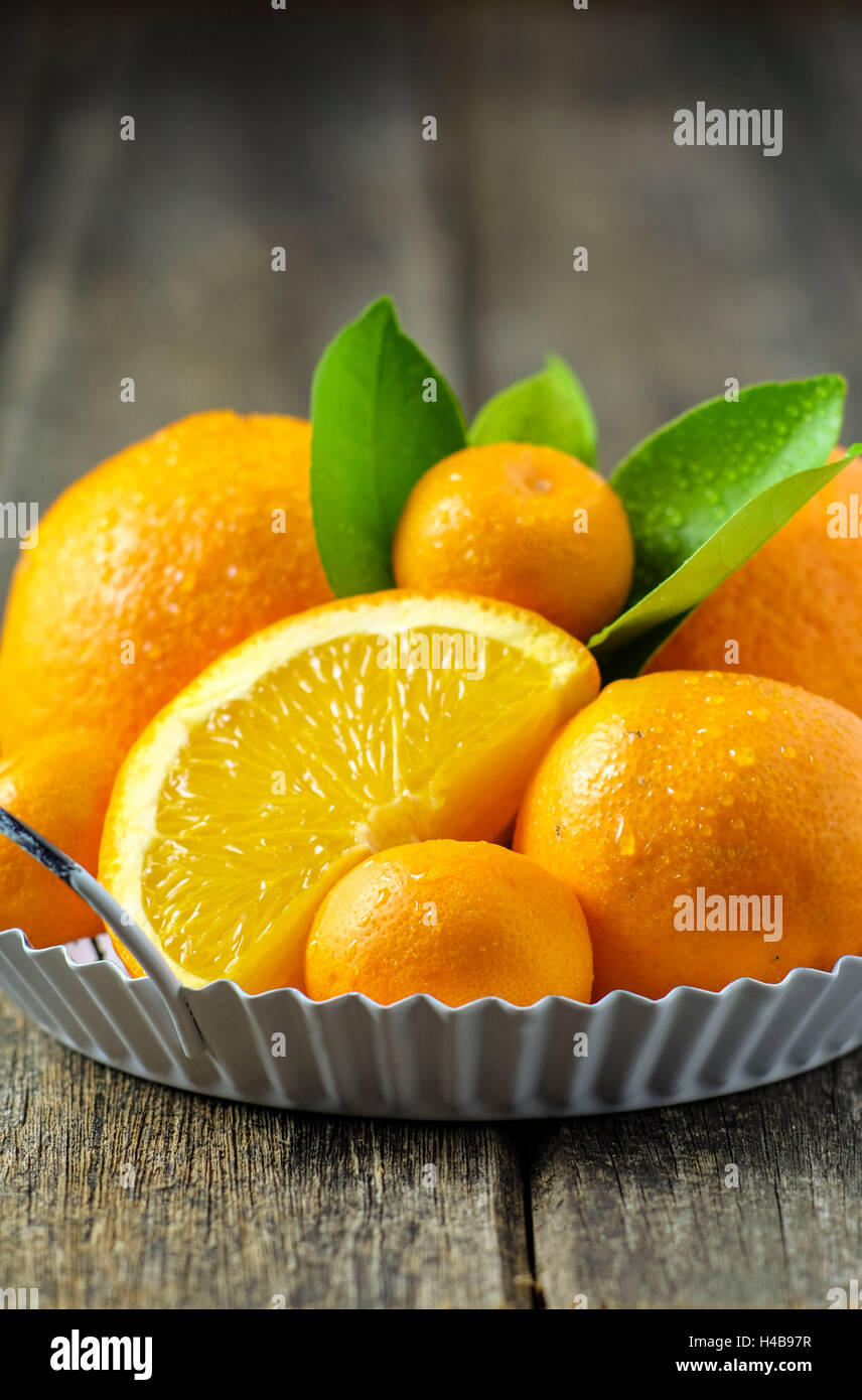 Arance e mandarini in un peel sul legno vecchio Foto Stock