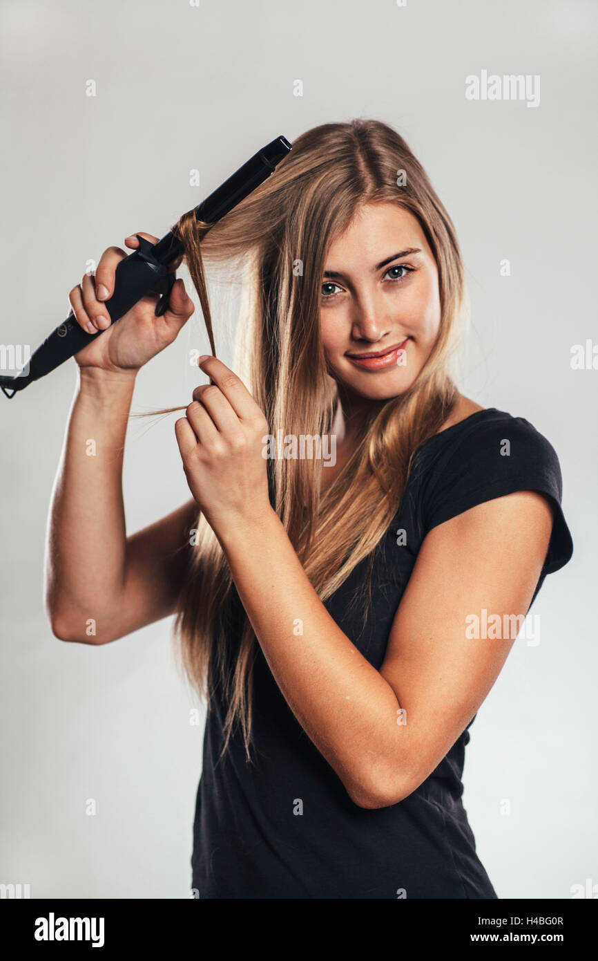 La donna riccioli di applicazione per i capelli Foto Stock