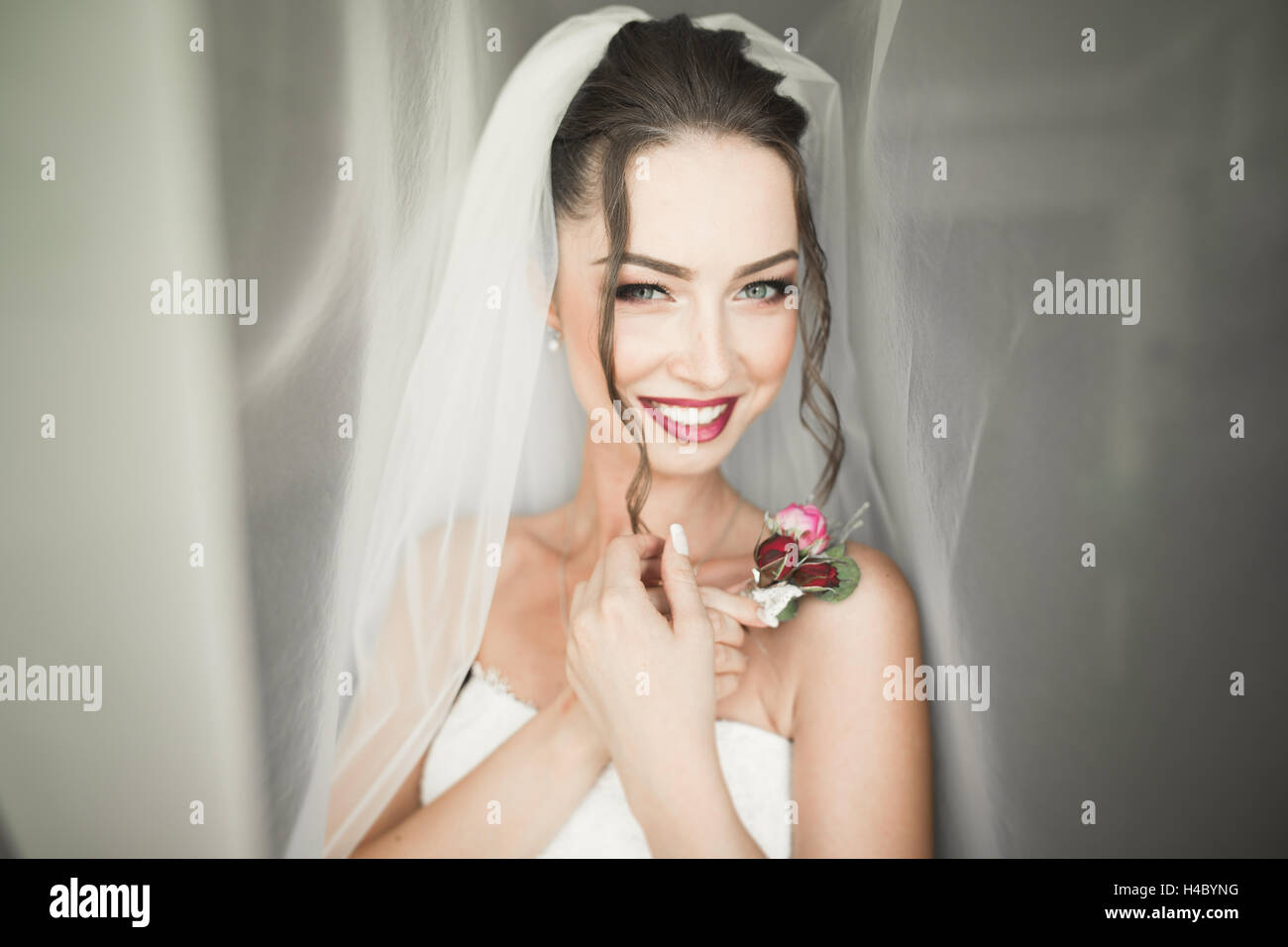 Bella giovane sposa con il Trucco e acconciatura in camera da letto, sposa donna finale di preparazione per il matrimonio. Felice ragazza in attesa per lo sposo. Ritratto soft focus Foto Stock