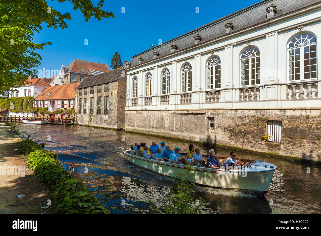 BRUGES, Belgio - Aprile 6, 2008: turisti galleggiare su una barca attraverso il Dijver canale vicino case vintage Foto Stock