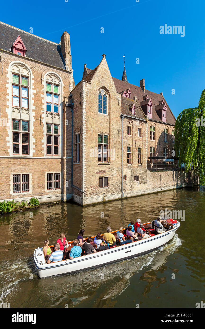 BRUGES, Belgio - Aprile 6, 2008: turisti galleggiare su una barca attraverso il Dijver canale vicino case vintage Foto Stock