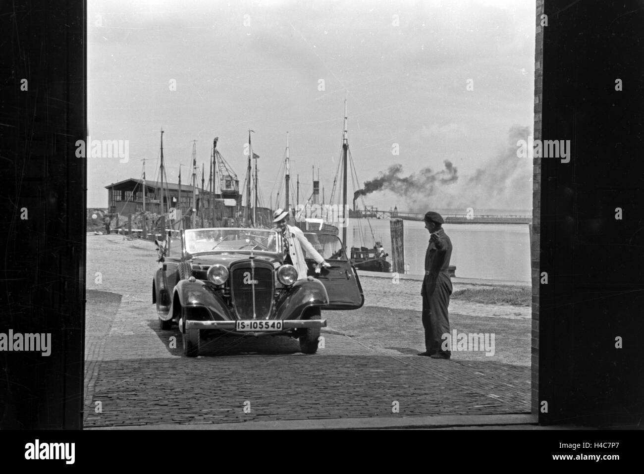 Eine Frau fährt ihr Audi Cabrio in eine der Garagen am Meer in Norddeich, Deutschland 1930er Jahre. Una donna alla guida la sua Audi convertibel in uno dei garage di Norddeich, Germania 1930 Foto Stock