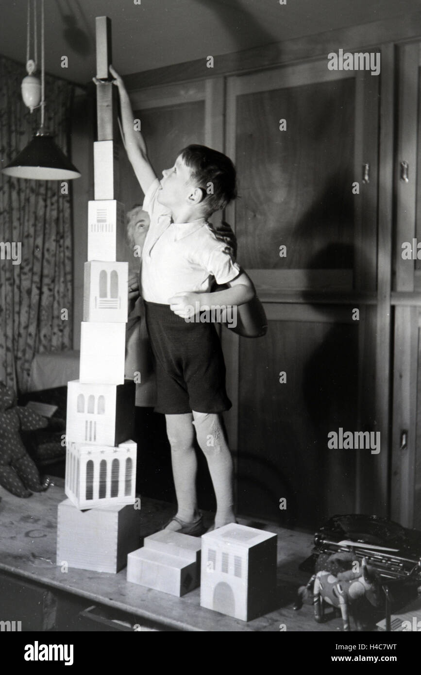 Eine Kunsthandwerkerin zeigt einem Jungen neue Spielsachen, Deutsches Reich 1930er Jahre. Un artigiano che mostra i nuovi giocattoli, Germania 1930 Foto Stock