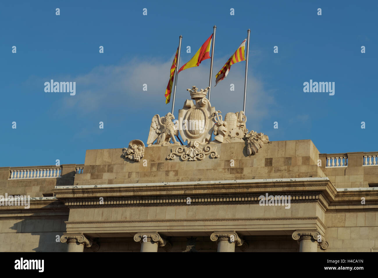 Barcellona, Spagna Municipio facciata in pietra stemma con le bandiere. Foto Stock