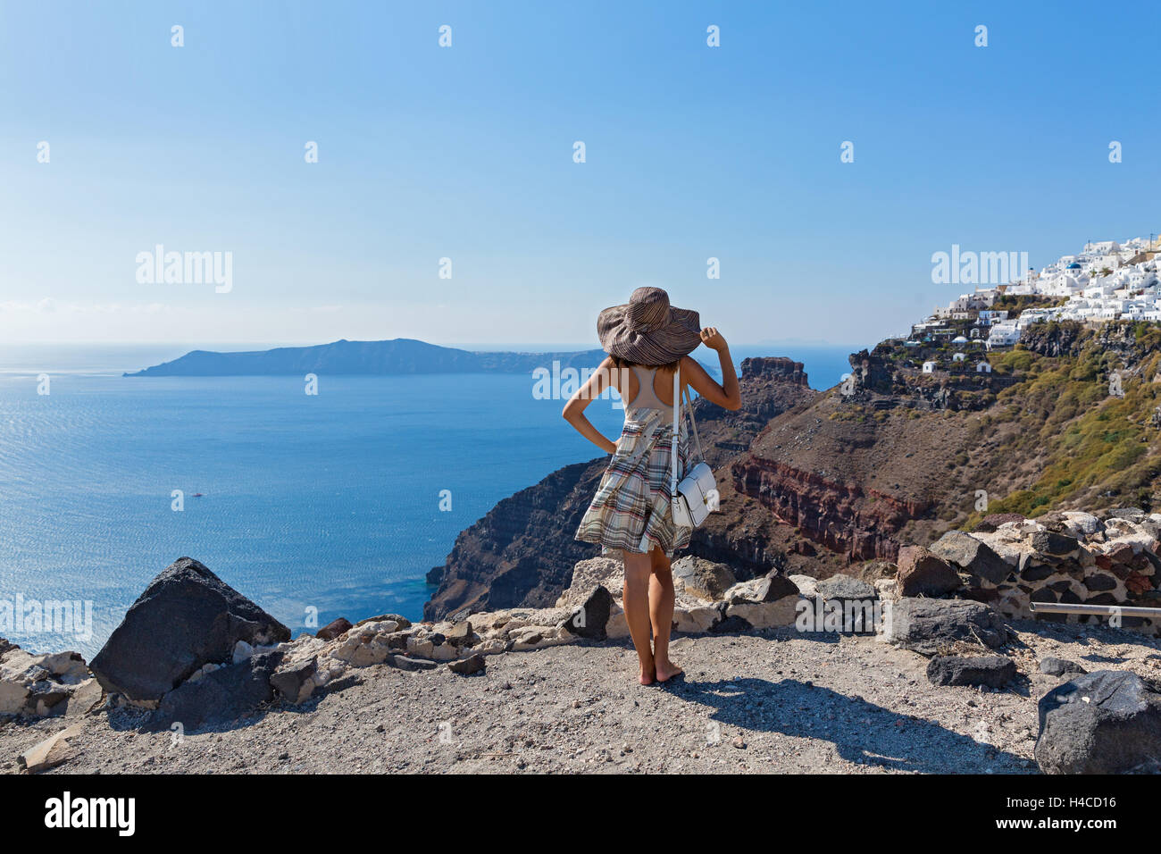 Giovane bella donna in hat guardando il mare, Santorini Foto Stock