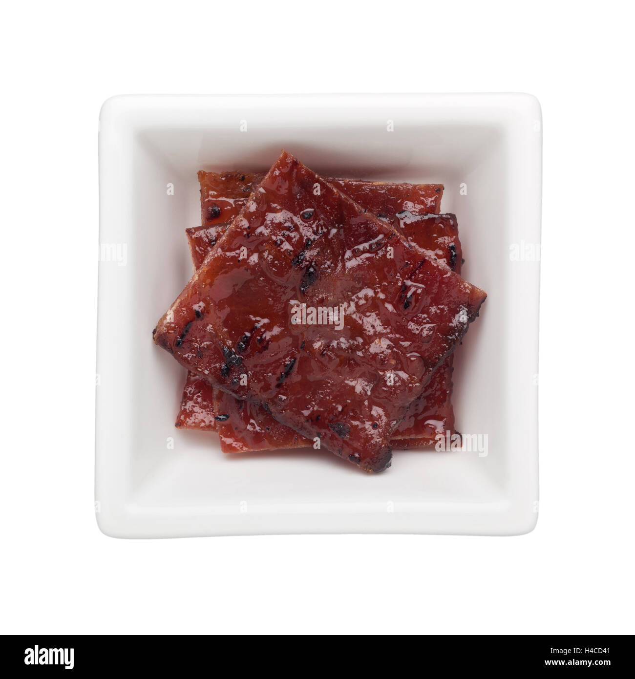 Bak Kwa - Chinese BBQ di maiale in una vaschetta quadrata isolati su sfondo bianco Foto Stock