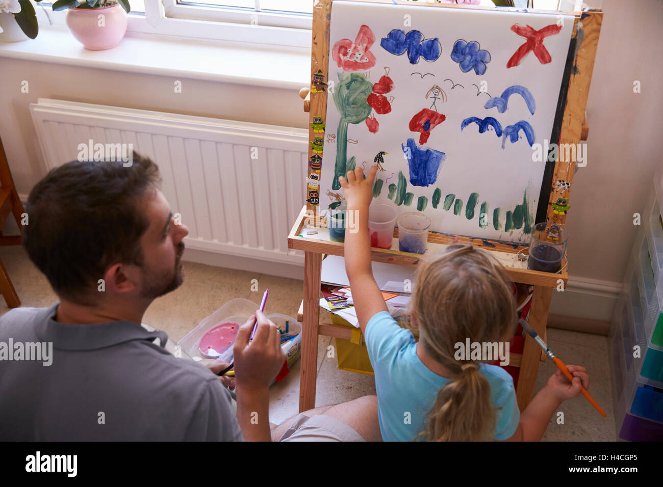 Padre e figlia dipingere un quadro a casa insieme Foto Stock