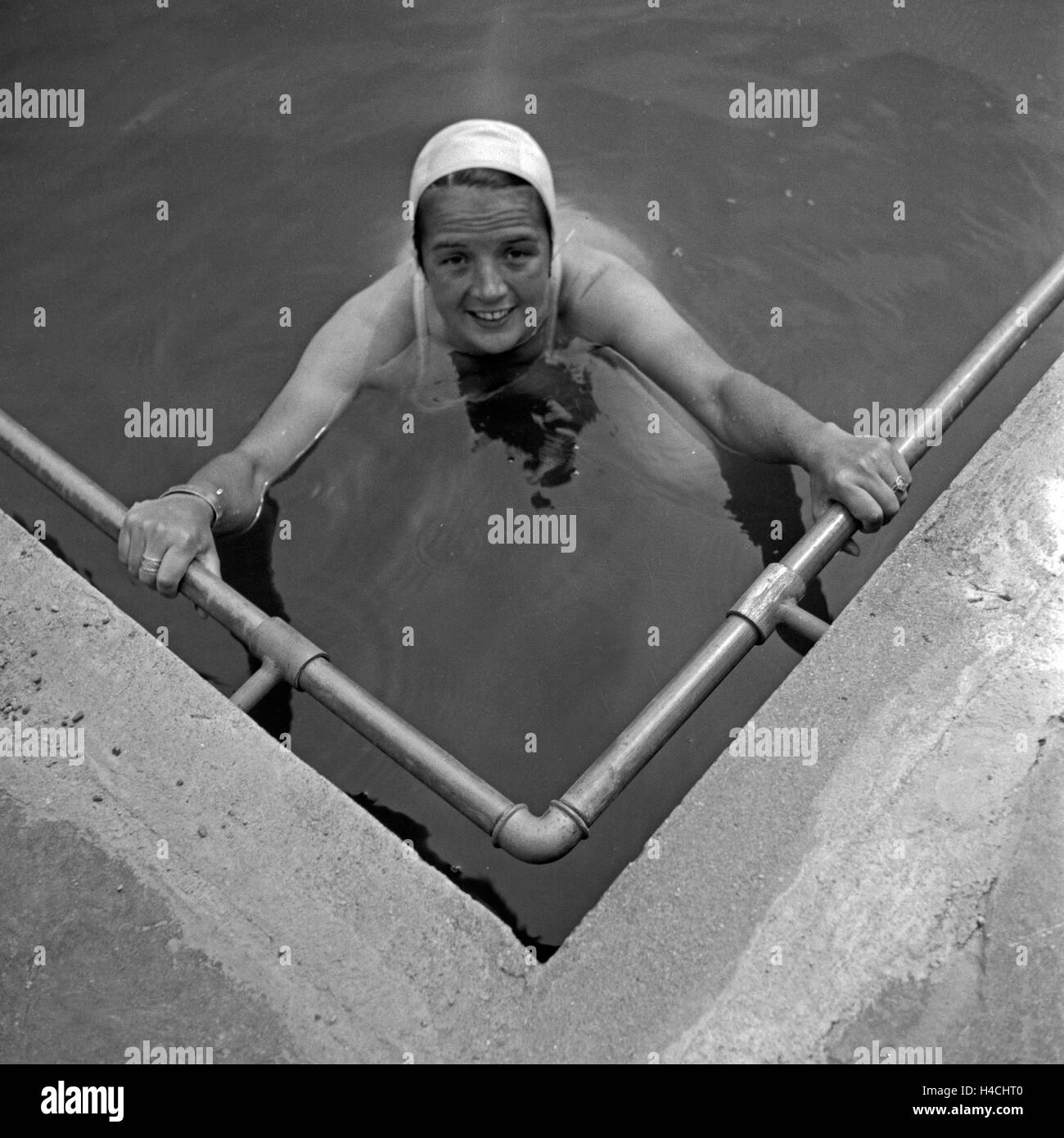 Eine junge Frau in der Ecke eines Schwimmbecken, Deutschland 1930er Jahre. Una giovane donna in un angolo di piscina all'aperto, Germania 1930s. Foto Stock