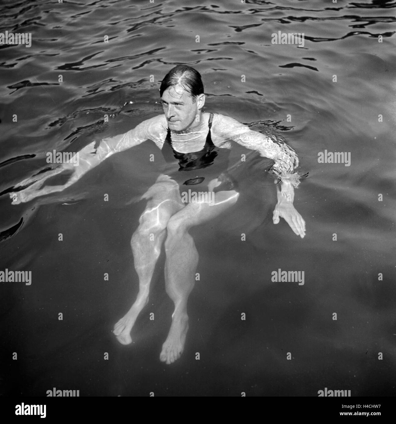 Ein Mann in einem Badeanzug schwimm in einem vedere, Deutschland 1930er Jahre. Un uomo in costume da bagno a nuotare in un lago, Germania 1930s. Foto Stock