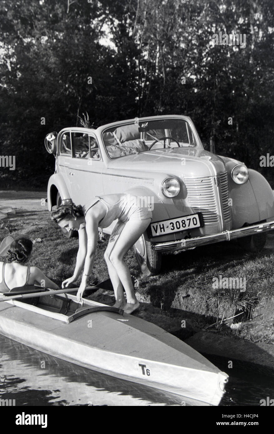 Junge Frau im Badeanzug steigt in ein Boot / Klepper T6 auf dem vedere, Deutschland 1930er Jahre. Giovane donna getting all'interno di una barca / Klepper T6 su un lago, Germania 1930 Foto Stock