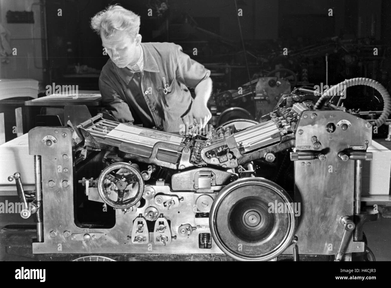 Ein Drucker bei der Arbeit an der M.A.N. Maschine "Poly brevetto", Deutsches Reich 1930er Jahre. Una stampante funzionante con la macchina M.A.N. "Poly brevetto", Germania 1930 Foto Stock