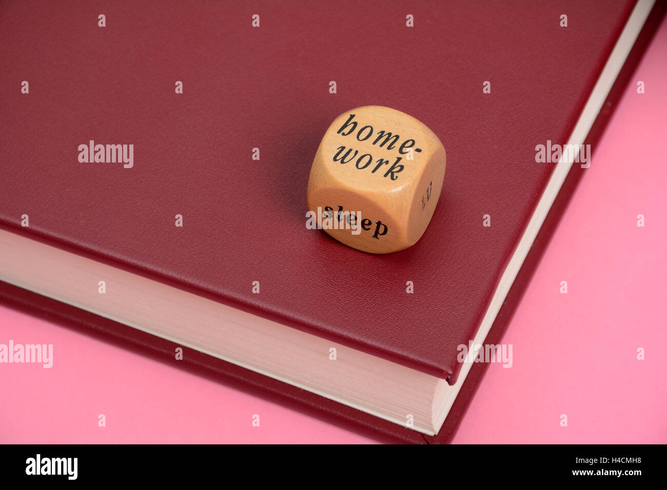 Lavoro a casa il sonno parole su legno dadi con libro. Foto Stock