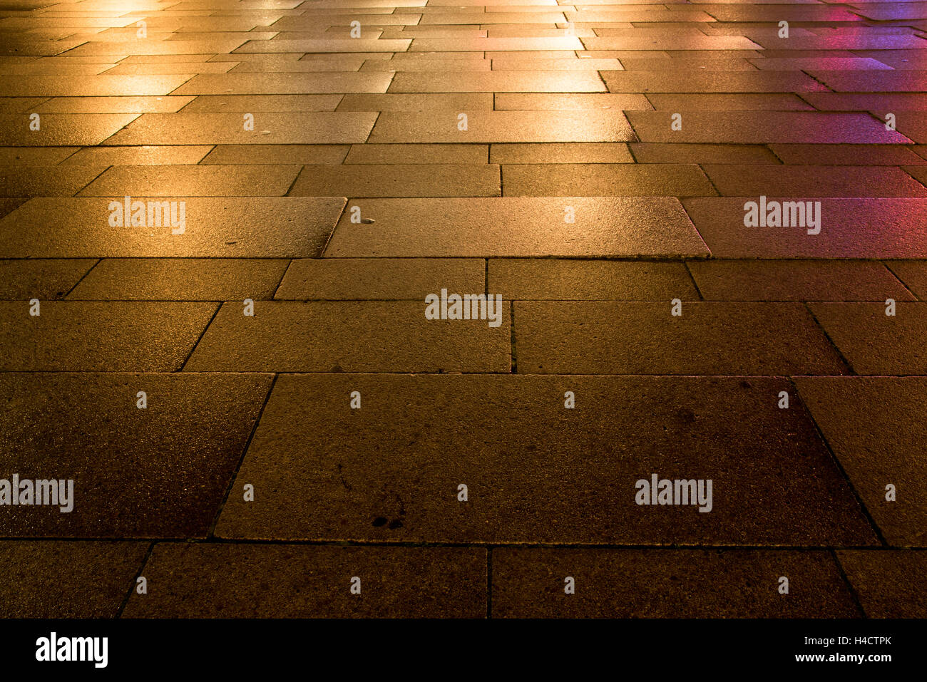 La riflessione delle luci sul pavimento bagnato nella città Foto Stock