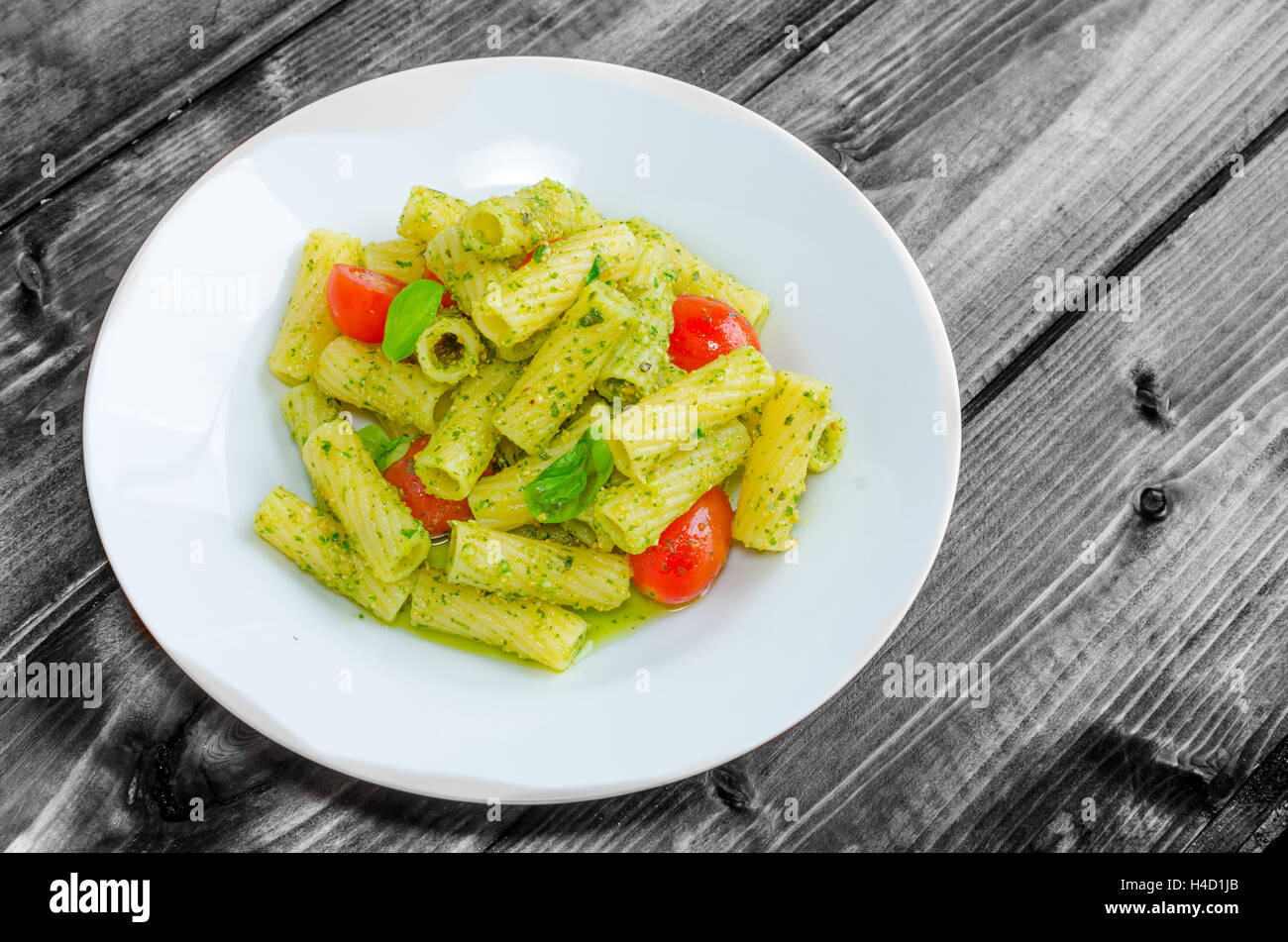 Rigatoni Pasta con pesto alla genovese e lo sherry di pomodoro su legno Foto Stock