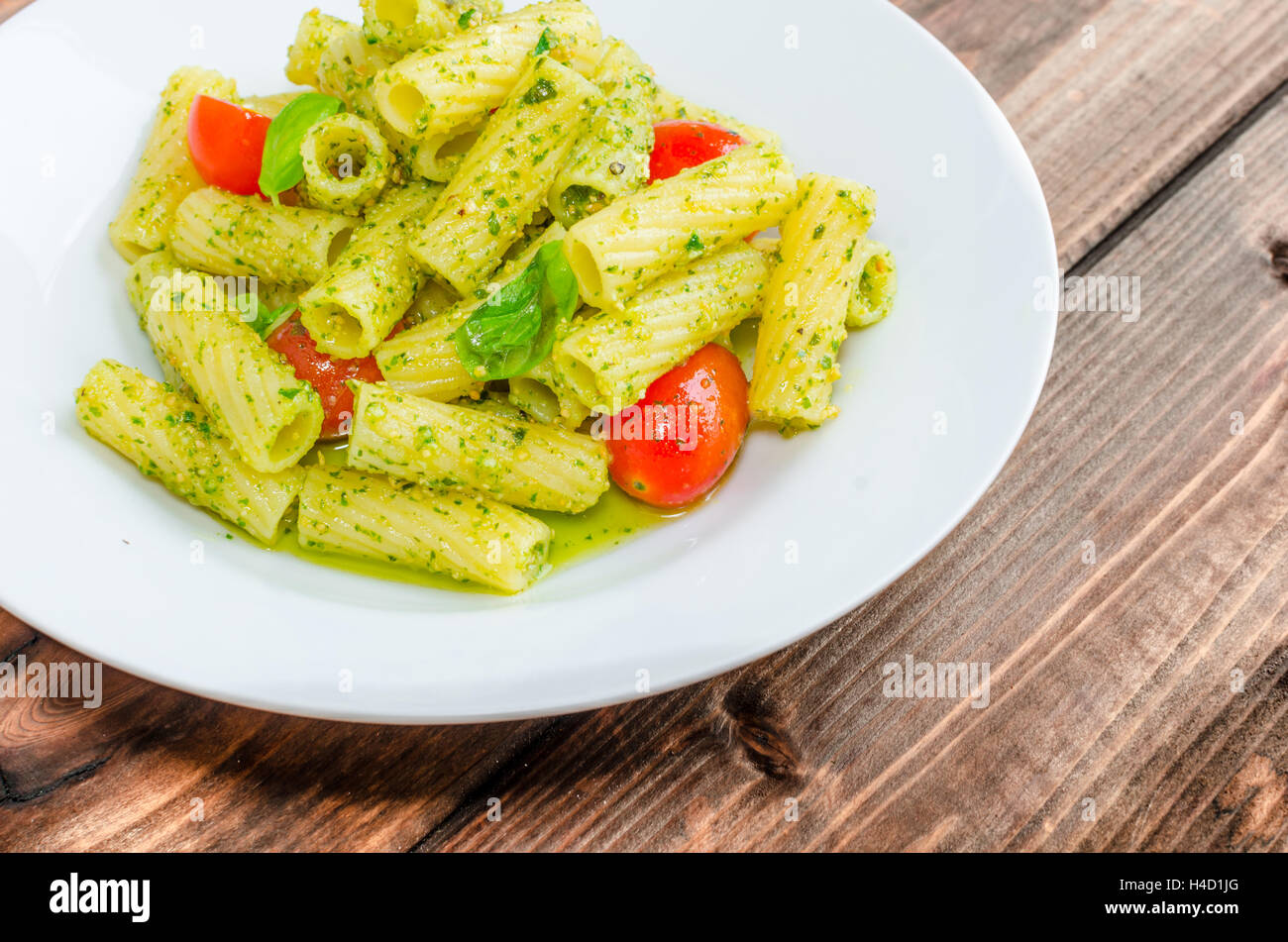 Rigatoni Pasta con pesto alla genovese e lo sherry di pomodoro su legno Foto Stock