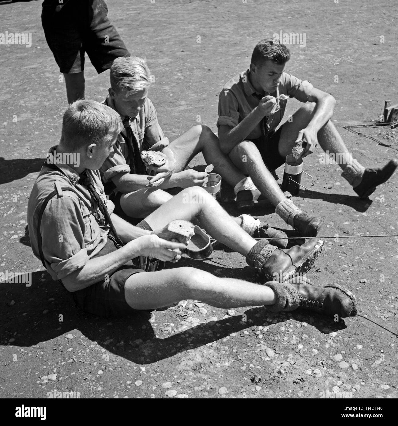 Drei Hitlerjungen sitzen in der Mittagspause zusammen beim feldmäßigen Essen, Österreich 1930er Jahre. Tre giovani Hitler seduti insieme e avente la pausa pranzo, Austria 1930s. Foto Stock