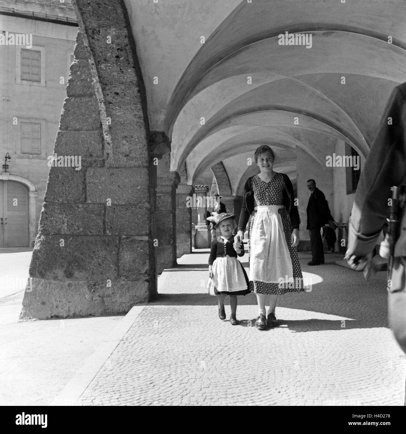 Eine Mutter und ihre kleine Tochter spazieren durch die Kolonnaden des Ehrenmals für die im 1. Weltkrieg Gefallenen a Berchtesgaden, Deutschland 1930er Jahre. Una madre a spasso con la sua piccola figlia attraverso i colonnati del Berchtesgaden WWI palazzo Foto Stock