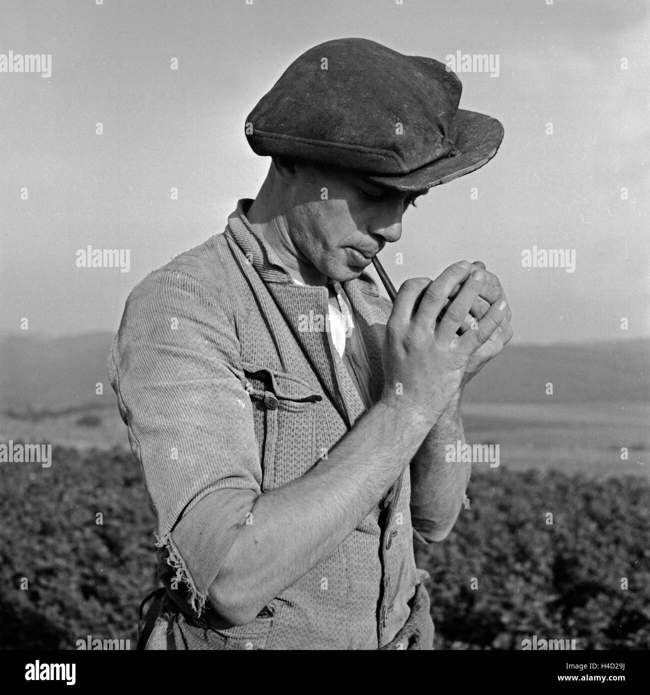 Ein Bauer in der Eifel zündet sich zur Arbeit eine Pfeife un, Deutschland 1930er Jahre. Un agricoltore della regione Eifel lighting il suo tubo, Germania 1930s. Foto Stock