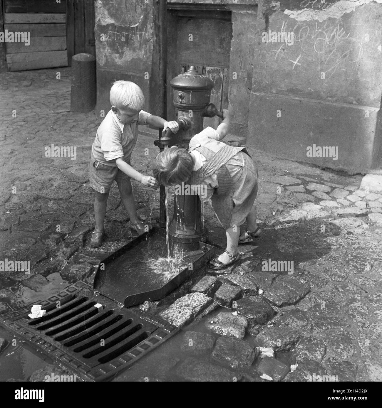 Zwei kleine Jungen trinken un einem Brunnen in der Innenstadt von Königsberg in Ostpreußen, Deutschland 1930er Jahre. Due ragazzini di bere da un pozzetto all'interno della città di Koenigsberg in Prussia orientale, Germania 1930s. Foto Stock