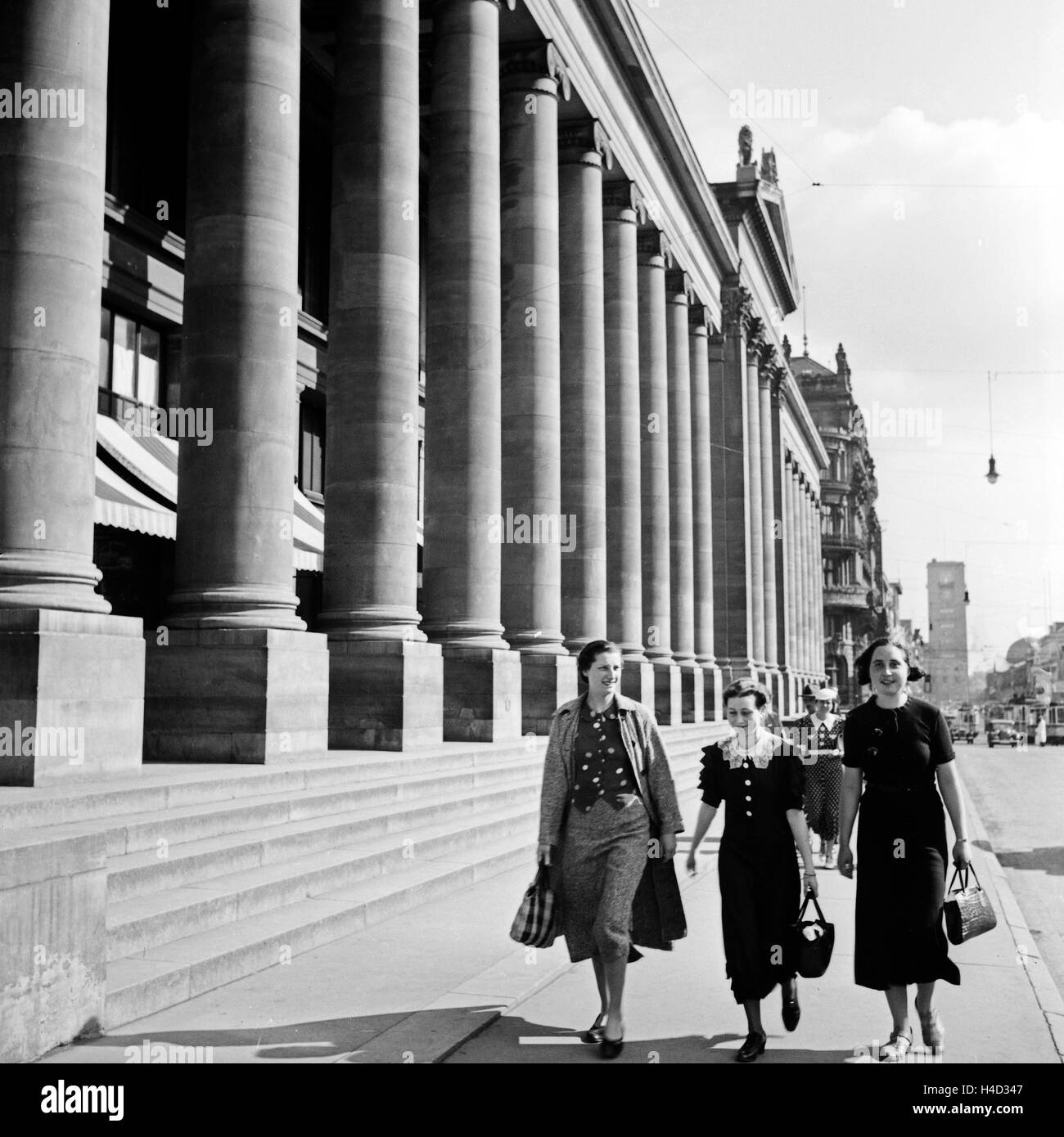 Drei Frauen kommen vom Einkauf am Königsbau a Stoccarda vorbei, Deutschland 1930er Jahre. Tre donne provenienti dai negozi lungo il palazzo Koenigsbau a Stoccarda, Germania 1930s. Foto Stock