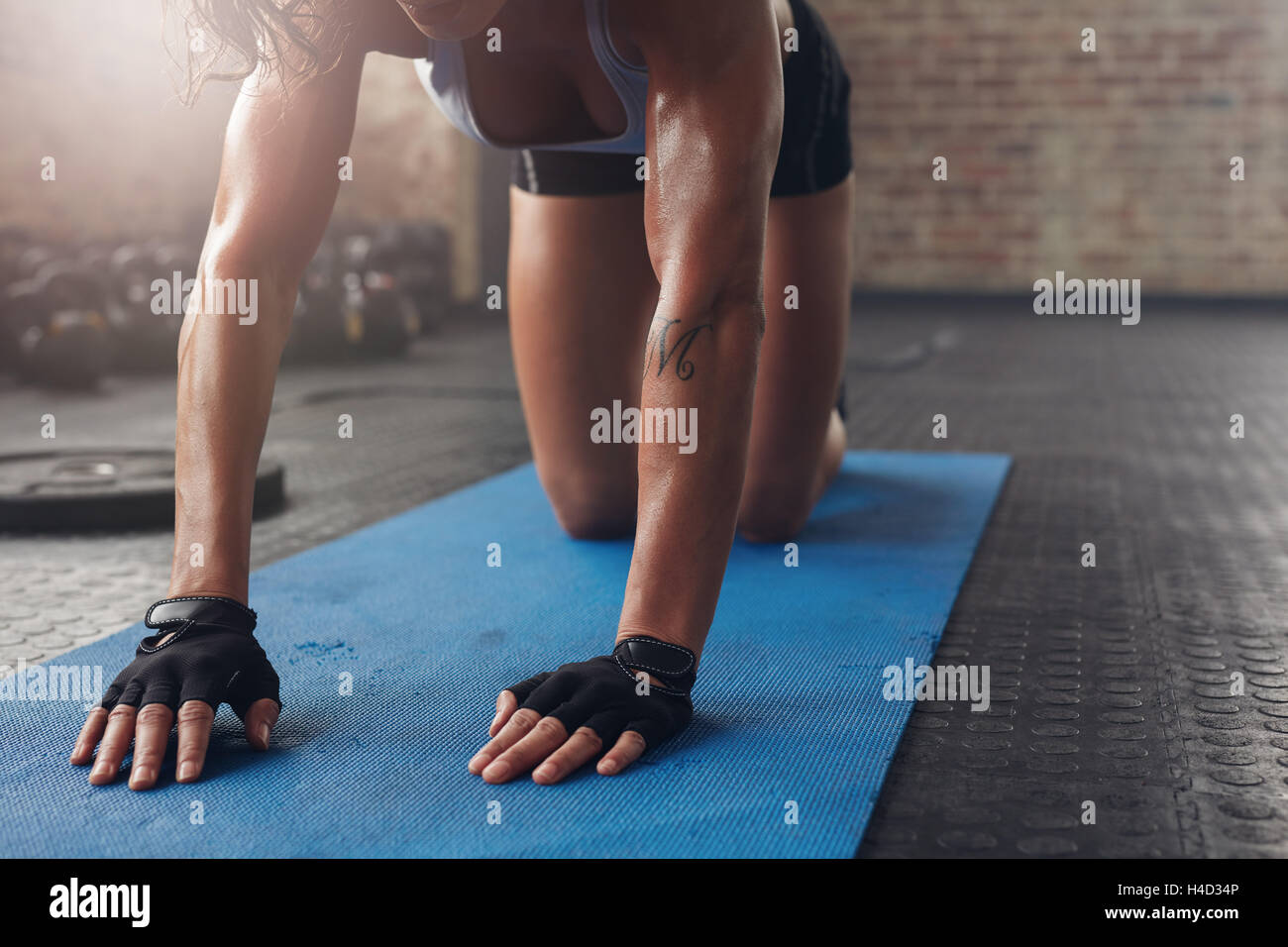 Femmina su esercizio mat facendo stretching allenamento. Focus sulla mano di una donna sul tappetino fitness. Foto Stock