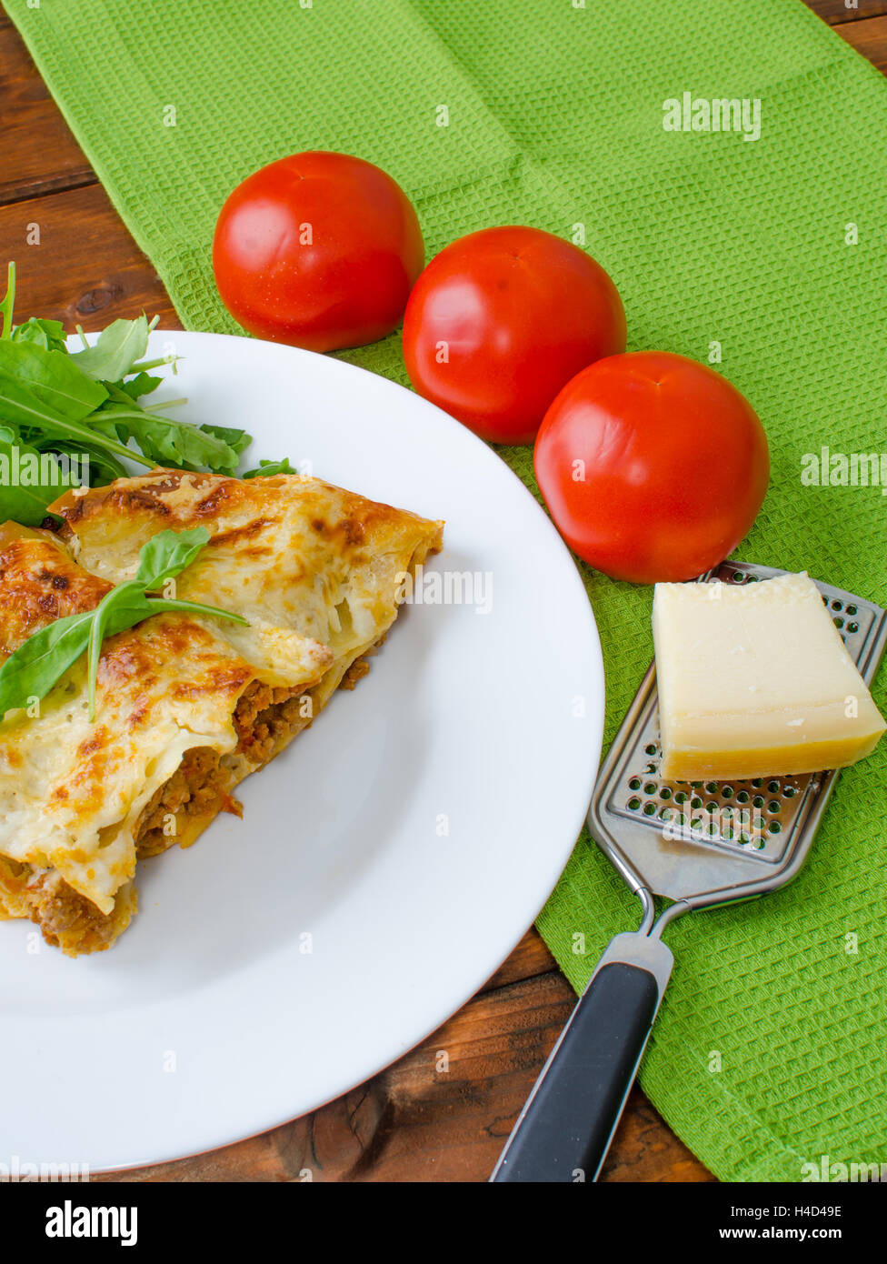 Lasagne alla bolognese sulla piastra bianca, pomodoro e Grattuggia formaggio Foto Stock