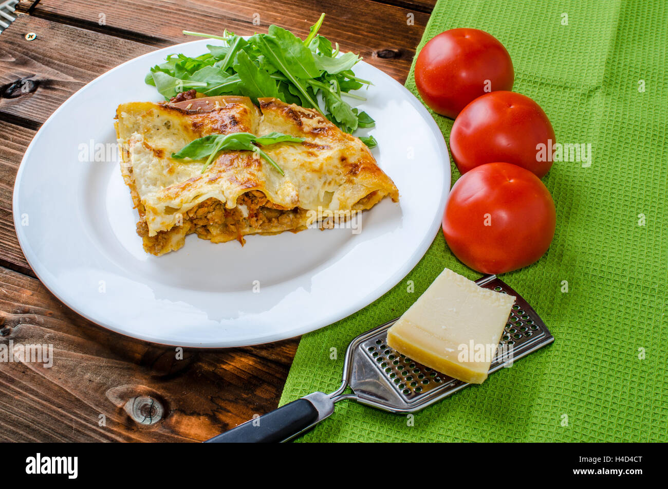Lasagne alla bolognese sulla piastra bianca, pomodoro e Grattuggia formaggio Foto Stock