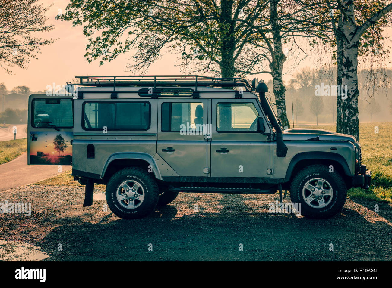 Veicolo fuoristrada Defender 110, alberi, retroilluminazione HDR Foto Stock