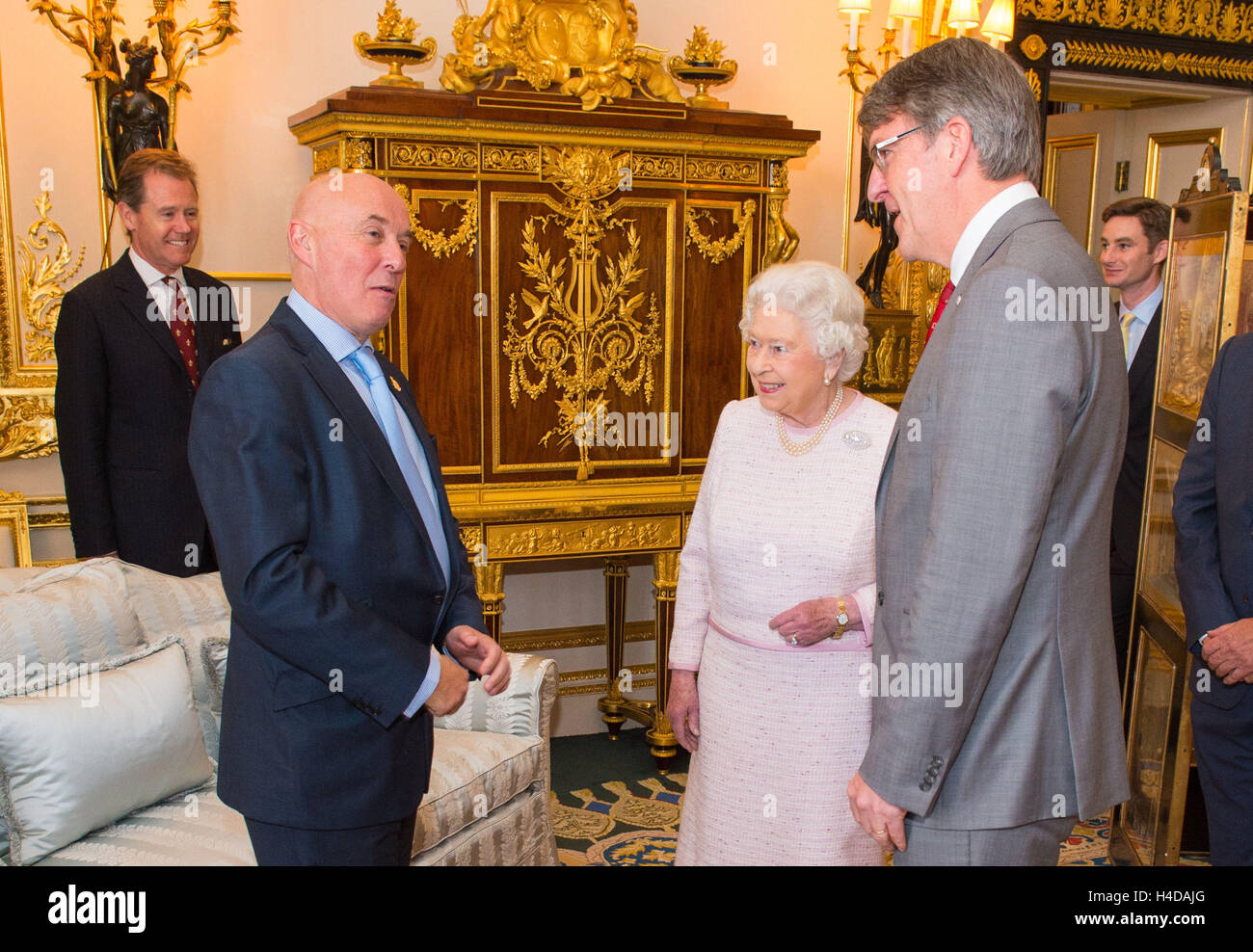 Queen Elizabeth II incontra la Croce Rossa Direttore Esecutivo di fundraising Marco Astarita (sinistra) e la Croce Rossa Chief Executive Michael Adamson (a destra), all'inaugurazione di un ritratto della sua dall artista britannico Henry Ward, segnando sei decenni di patrocinio alla Croce Rossa Britannica, che è stato presentato al Castello di Windsor in Berkshire. Foto Stock